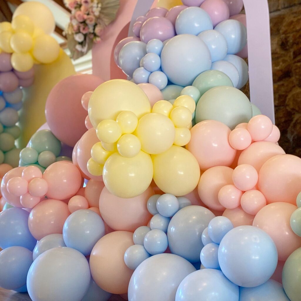 Organic balloon installation with oversized and custom-colored balloons cascading across a wall