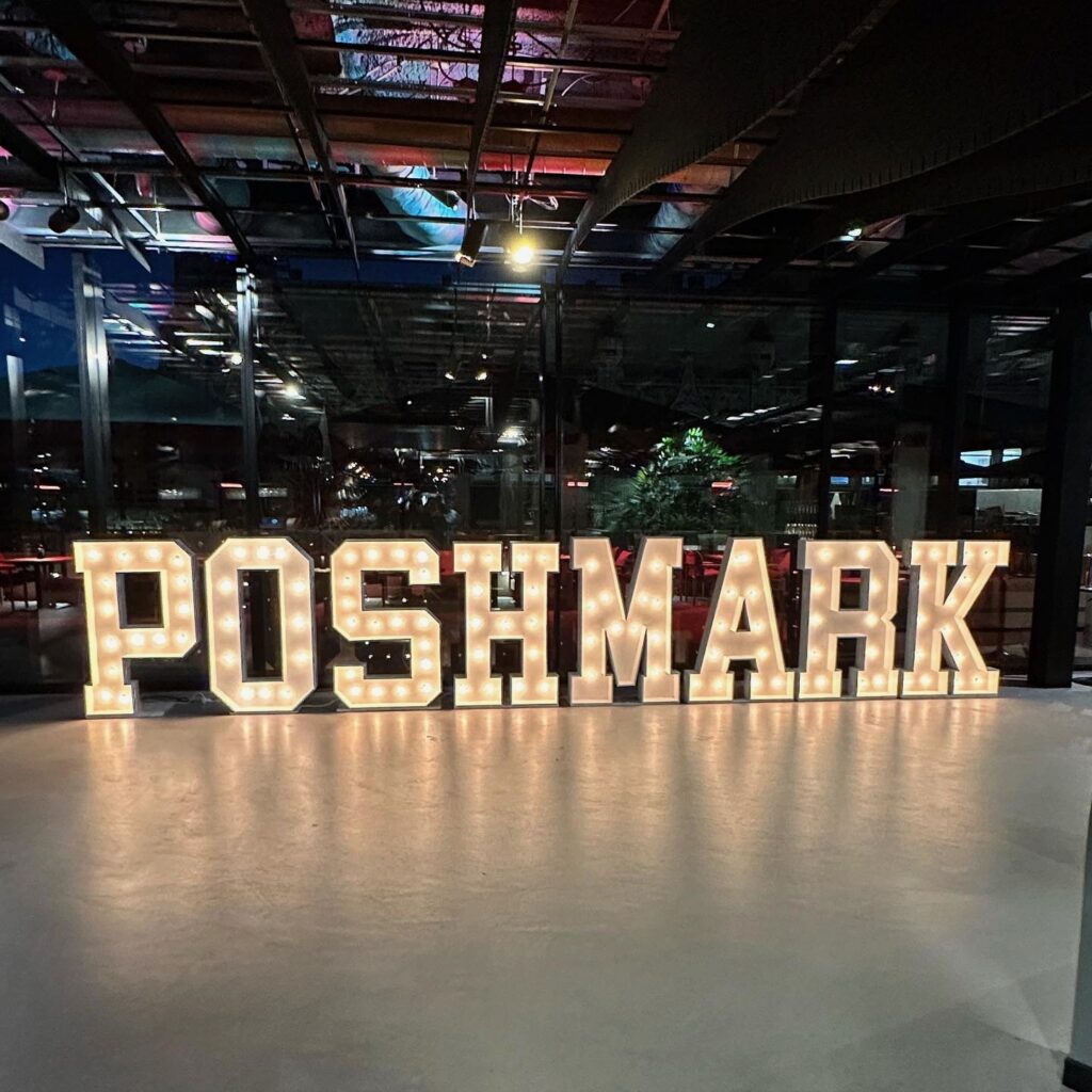 Illuminated marquee letters spelling out a celebratory message at an outdoor event