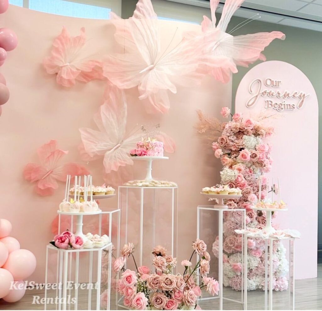 White geometric pedestals arranged as a floral and dessert display